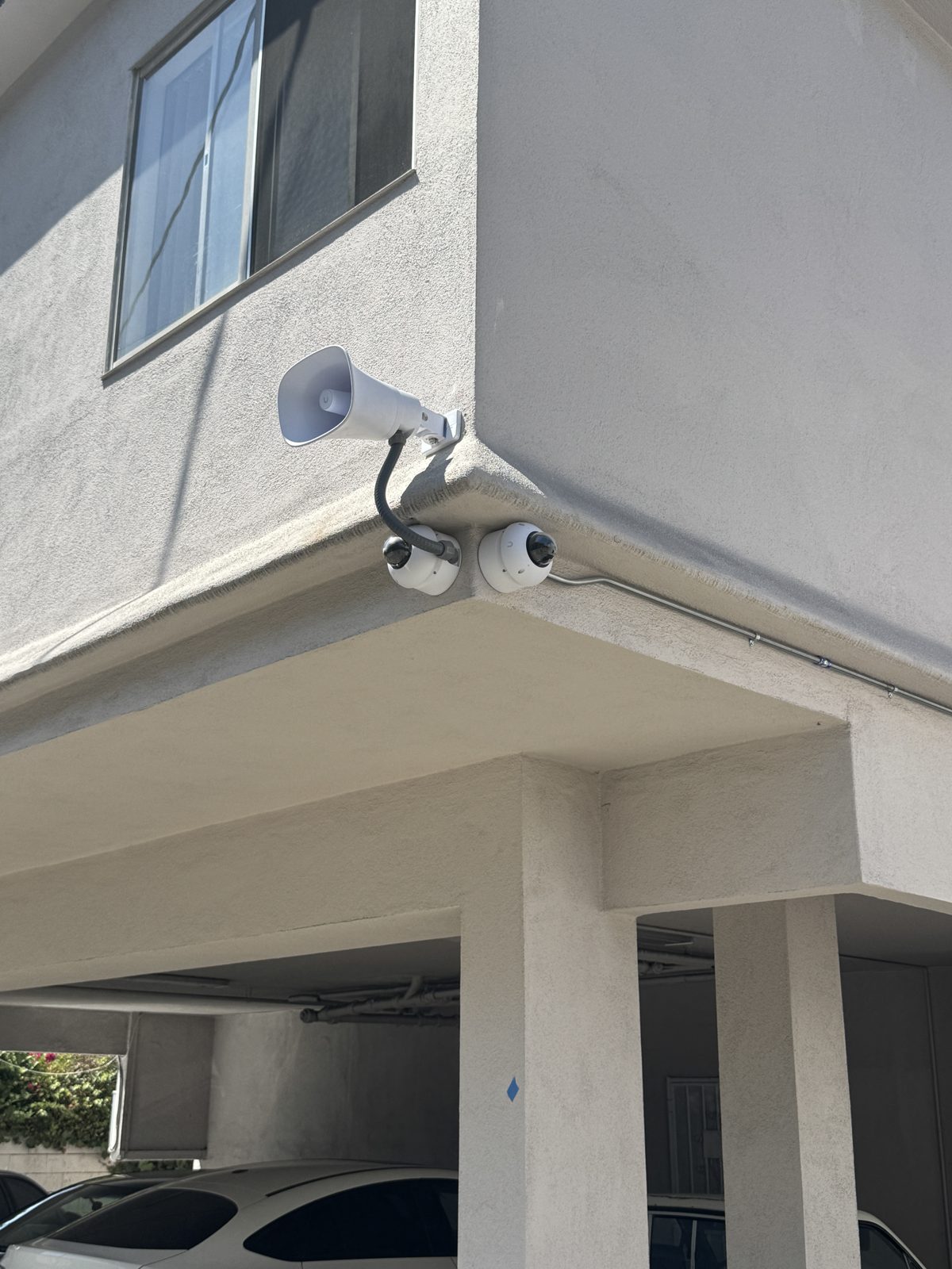 UniFi dome cameras and talk-down speaker at a Los Angeles apartment carport